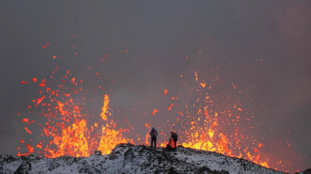 Un equipo de científicos trabaja hoy, en la cresta de una fisura volcánica mientras sale lava durante una erupción volcánica, cerca de la ciudad de Grindavik, en la península de Reykjanes (Islandia).