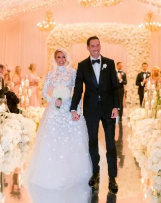 La primera foto del primero de los diez vestidos que ha preparado para su enlace con el empresario es un diseño blanco inmaculado de encaje tradicional con manga larga, cuello perkins y un velo de tul. La primera foto del primero de los diez vestidos que ha preparado para su enlace con el empresario es un diseño blanco inmaculado de encaje tradicional con manga larga, cuello perkins y un velo de tul.