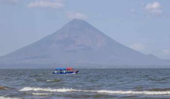 Una embarcación de turistas navega en el lago cocibolca frente al volcán concepción de la isla de Ometepe este jueves, en la ciudad de Rivas, Nicaragua.