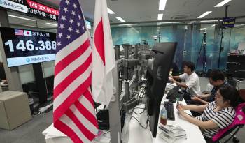 Los comerciantes de dinero revisan los monitores durante una sesión de negociación del dólar estadounidense y el yen japonés, en Tokio, en una fotografía de archivo.