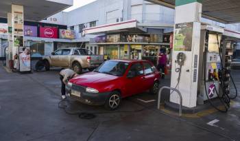 La gente pone aire en los neumáticos de sus autos en una estación de servicio en Salto, Uruguay.