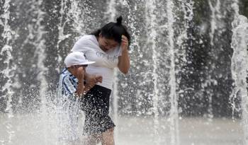Foto de archivo de dos personas que se refrescan en una fuente de la Ciudad de México (México) para combatir las altas temperaturas. EFE/Isaac Esquivel