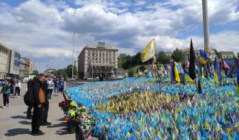 Un grupo de ucranianos rinde homenaje a los caídos en la guerra en el mar de banderas que recuerda a los soldados ucranianos y extranjeros muertos en combate en la guerra con Rusia, el pasado 16 de mayo en Kiev (Ucrania).