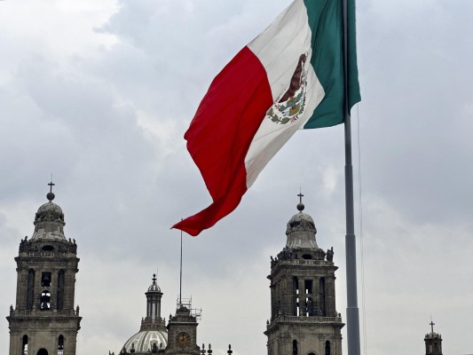 La bandera mexicana ondea frente a la Catedral Metropolitana en una imagen de archivo. La bandera mexicana ondea frente a la Catedral Metropolitana en una imagen de archivo.