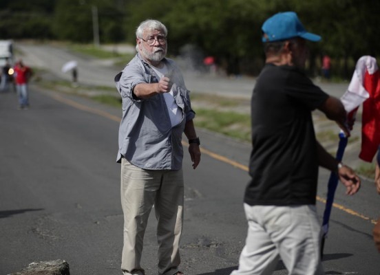 Un hombre dispara un arma hacia un manifestante en medio de un bloqueo de docentes en la vía Panamericana hoy, en Chame (Panamá). Un hombre dispara un arma hacia un manifestante en medio de un bloqueo de docentes en la vía Panamericana hoy, en Chame (Panamá).