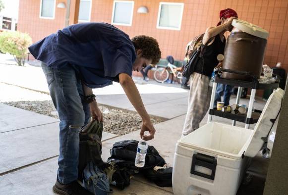 La gente busca hielo y agua afuera en un centro de enfriamiento del Ejército de Salvación para personas sin hogar en Tucson, Arizona, el 26 de julio de 2023. La gente busca hielo y agua afuera en un centro de enfriamiento del Ejército de Salvación para personas sin hogar en Tucson, Arizona, el 26 de julio de 2023.