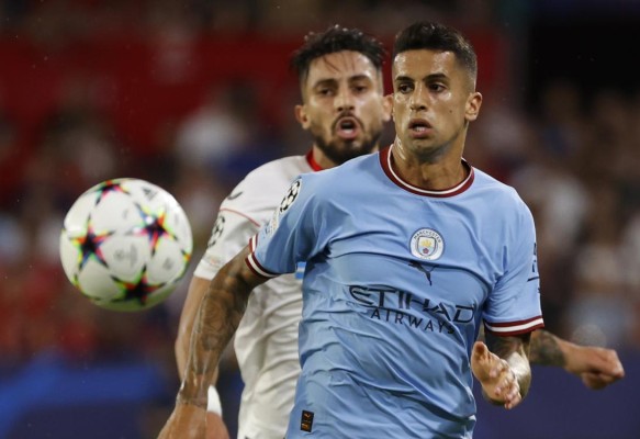 El jugador brasileño del Sevilla Álex Telles persigue al portugués Joao Cancelo, del Manchester City, durante el encuentro disputado entre ambos equipos en el Sánchez Pizjuán. El jugador brasileño del Sevilla Álex Telles persigue al portugués Joao Cancelo, del Manchester City, durante el encuentro disputado entre ambos equipos en el Sánchez Pizjuán.