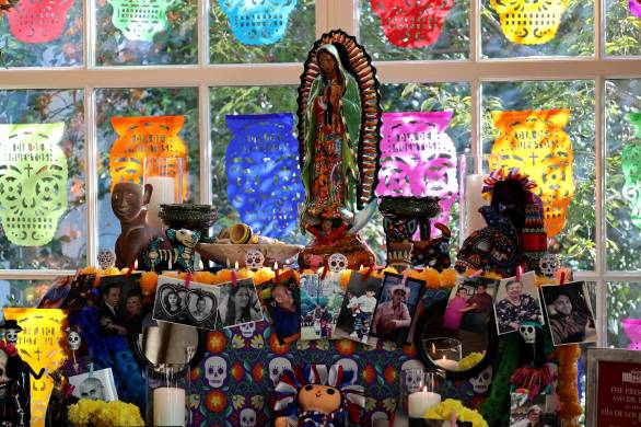 El altar está compuesto por tres niveles, decorados con calaveritas de azúcar, catrinas, pan de muerto, velas, papel picado y figuras mexicanas como alebrijes, que están coronados por una imagen de la virgen de Guadalupe y un arco de flores de cempasúchil. El altar está compuesto por tres niveles, decorados con calaveritas de azúcar, catrinas, pan de muerto, velas, papel picado y figuras mexicanas como alebrijes, que están coronados por una imagen de la virgen de Guadalupe y un arco de flores de cempasúchil.