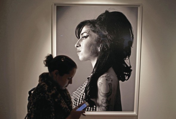 Un visitante pasa frente a un retrato de la fallecida cantante británica Amy Winehouse hecho por el cantante y compositor canadiense Bryan Adams. Un visitante pasa frente a un retrato de la fallecida cantante británica Amy Winehouse hecho por el cantante y compositor canadiense Bryan Adams.