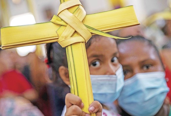 Una niña sostiene una cruz de palma durante la misa del Domingo de Ramos en el inicio de las festividades religiosas de Semana Santa, en Managua (Nicaragua). Una niña sostiene una cruz de palma durante la misa del Domingo de Ramos en el inicio de las festividades religiosas de Semana Santa, en Managua (Nicaragua).