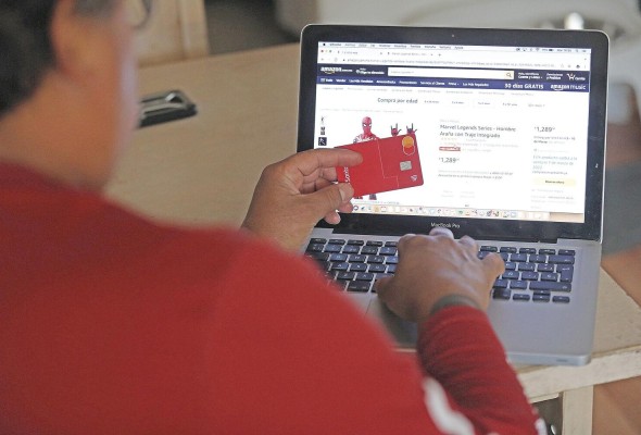 Una persona realiza una compra por internet con su tarjeta bancaria, en una fotografía de archivo. Una persona realiza una compra por internet con su tarjeta bancaria, en una fotografía de archivo.
