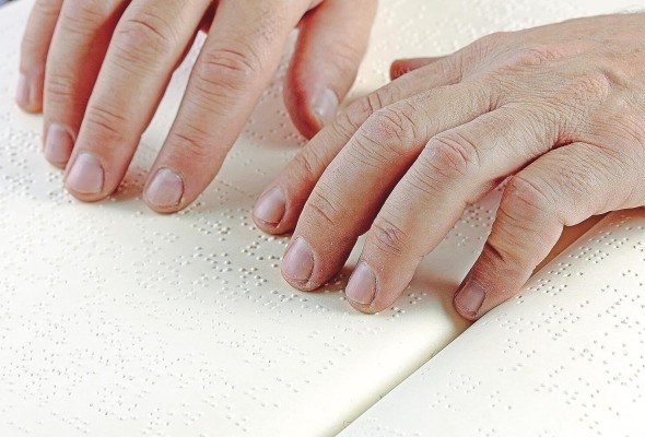 Una persona utilizando el sistema braille. Una persona utilizando el sistema braille.