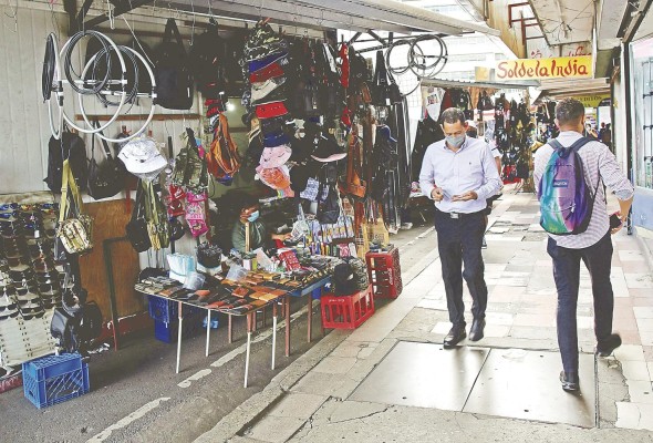 Varias personas caminan frente a un puesto de buhonería en Ciudad de Panamá (Panamá). Varias personas caminan frente a un puesto de buhonería en Ciudad de Panamá (Panamá).