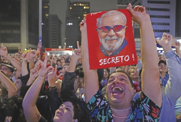 Simpatizantes del expresidente y candidato presidencial Luiz Inácio Lula da Silva celebran mientras se publican los resultados . Simpatizantes del expresidente y candidato presidencial Luiz Inácio Lula da Silva celebran mientras se publican los resultados .