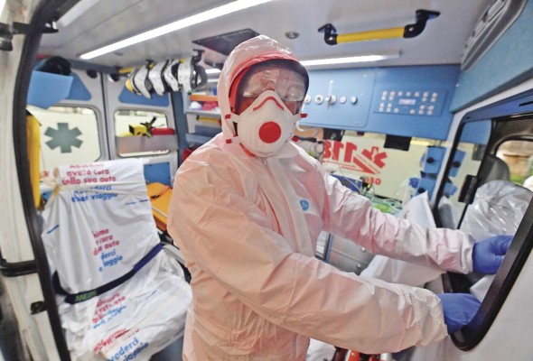 Trabajadores de la Cruz Blanca en Génova, Italia, se preparan con ropa de seguridad y mascarillas para recoger a sospechosos de contagio, el 13 de marzo. Trabajadores de la Cruz Blanca en Génova, Italia, se preparan con ropa de seguridad y mascarillas para recoger a sospechosos de contagio, el 13 de marzo.