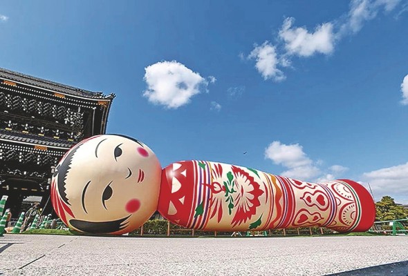 Una enorme muñeca Kokeshi adorna la puerta del templo Higashi Honganji. Una enorme muñeca Kokeshi adorna la puerta del templo Higashi Honganji.
