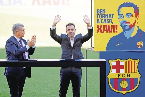El nuevo entrenador del FC Barcelona, Xavi Hernández, junto al presidente del club, Joan Laporta (i), saluda a los aficionados que se citaron en las gradas del Camp Nou durante el acto de presentación como entrenador blaugrana. El nuevo entrenador del FC Barcelona, Xavi Hernández, junto al presidente del club, Joan Laporta (i), saluda a los aficionados que se citaron en las gradas del Camp Nou durante el acto de presentación como entrenador blaugrana.