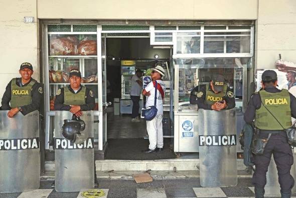 Policías custodian afuera de un negocio comercial Policías custodian afuera de un negocio comercial