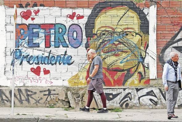 Un hombre pasa frente a un grafiti del candidato presidencial Gustavo Petro en Bogotá. Un hombre pasa frente a un grafiti del candidato presidencial Gustavo Petro en Bogotá.