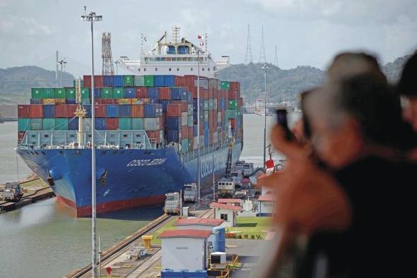 Turistas observan el tránsito de un buque portacontenedores en el Canal de Panamá, en una fotografía de archivo. Turistas observan el tránsito de un buque portacontenedores en el Canal de Panamá, en una fotografía de archivo.