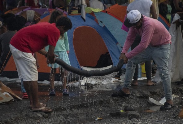 Familias completas atraviesan a pie la frontera con Panamá hasta el campamento improvisado en un antiguo aeródromo en Paso Canoas. Familias completas atraviesan a pie la frontera con Panamá hasta el campamento improvisado en un antiguo aeródromo en Paso Canoas.