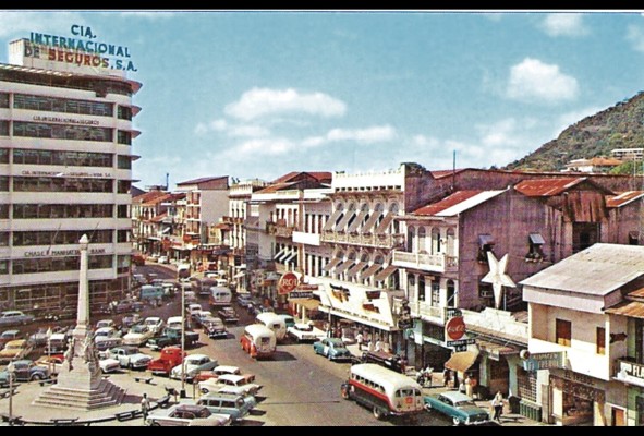 Avenida Central y plaza 5 de Mayo. Circa 1960. La popularización del automóvil y el transporte público facilitó la expansión del extrarradio manteniendo aun los centros comerciales y administrativos en el centro histórico durante buena parte del siglo XX. Avenida Central y plaza 5 de Mayo. Circa 1960. La popularización del automóvil y el transporte público facilitó la expansión del extrarradio manteniendo aun los centros comerciales y administrativos en el centro histórico durante buena parte del siglo XX.