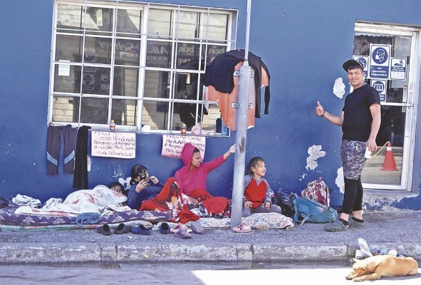 Una familia de personas pide ayuda en una calle, en una fotografía de archivo. Una familia de personas pide ayuda en una calle, en una fotografía de archivo.