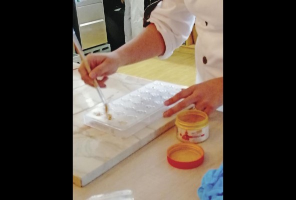 Mientras, se preparan los moldes de policarbonato que le dan la forma final a los bombones. Cada molde es limpiado y pulido antes de aplicar la pintura. Mientras, se preparan los moldes de policarbonato que le dan la forma final a los bombones. Cada molde es limpiado y pulido antes de aplicar la pintura.