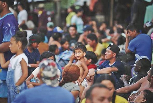 Migrantes hacen fila para dar sus datos personales a agentes de migración. Migrantes hacen fila para dar sus datos personales a agentes de migración.