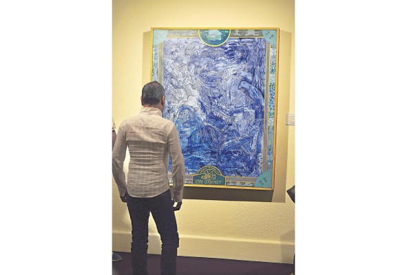 Un hombre admira una obra del pintor Ureña Ramos. Un hombre admira una obra del pintor Ureña Ramos.