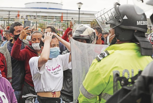 La policía requisa a un manifestante de la llamada 'primera línea', que son quienes enfrentan a la policía durante los disturbios. La policía requisa a un manifestante de la llamada 'primera línea', que son quienes enfrentan a la policía durante los disturbios.