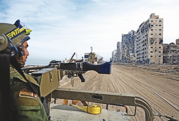 Un soldado israelí sentado en un vehículo militar conduciendo por una calle durante una operación militar en el norte de la Franja de Gaza. Un soldado israelí sentado en un vehículo militar conduciendo por una calle durante una operación militar en el norte de la Franja de Gaza.