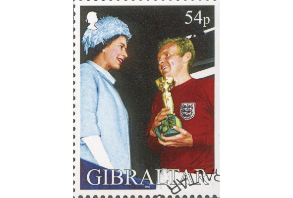 Sello postal de Gibraltar que muestra a Bobby Moore, capitán de Inglaterra, recibiendo el trofeo Jules Rimet de manos de la reina Isabel II. Sello postal de Gibraltar que muestra a Bobby Moore, capitán de Inglaterra, recibiendo el trofeo Jules Rimet de manos de la reina Isabel II.