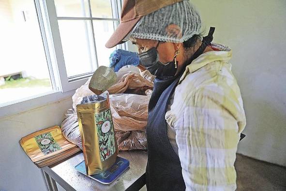 Una mujer empaca el café La Ceiba. Una mujer empaca el café La Ceiba.