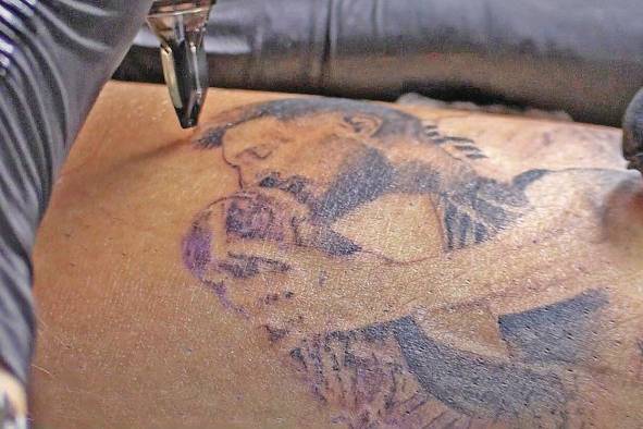 Una persona se hace un tatuaje de Messi besando la copa. Una persona se hace un tatuaje de Messi besando la copa.