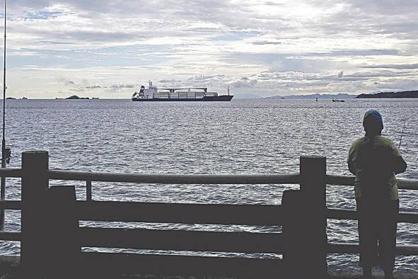 Un hombre pesca en un muelle frente al Canal de Panamá. Un hombre pesca en un muelle frente al Canal de Panamá.