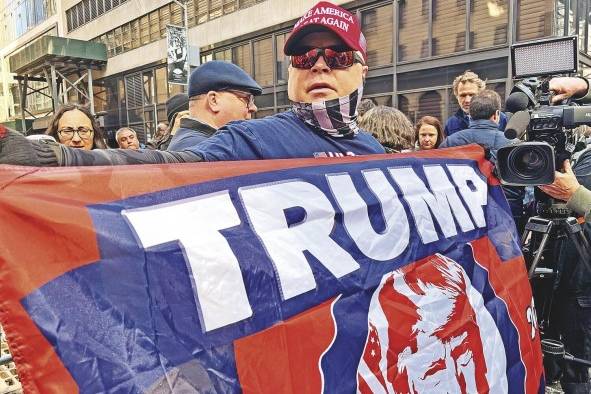 Dion Cini, quien organizó por redes sociales la marcha de “regreso a casa” para Trump, sostiene una bandera con la imagen del exmandatario. Dion Cini, quien organizó por redes sociales la marcha de “regreso a casa” para Trump, sostiene una bandera con la imagen del exmandatario.
