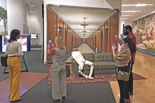 Personas toman fotografías con sus teléfonos móviles al telón pintado creado para la película 'Beginning of the End', puesto detrás del sillón usado en la película 'Singin in the Rain', durante un pase especial a la exhibición 'Art of the Hollywood Backdrop: Cinema's Creative Legacy' en el Museo de Arte de Boca Ratón, Florida. Personas toman fotografías con sus teléfonos móviles al telón pintado creado para la película 'Beginning of the End', puesto detrás del sillón usado en la película 'Singin in the Rain', durante un pase especial a la exhibición 'Art of the Hollywood Backdrop: Cinema's Creative Legacy' en el Museo de Arte de Boca Ratón, Florida.