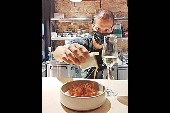 El chef vierte la leche de tigre sobre el tiradito El chef vierte la leche de tigre sobre el tiradito