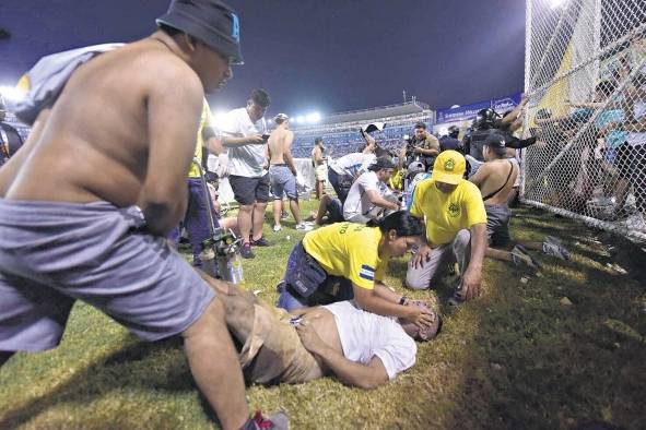 Fanáticos y personal de emergencia dan los primeros auxilios a los afectados. Fanáticos y personal de emergencia dan los primeros auxilios a los afectados.