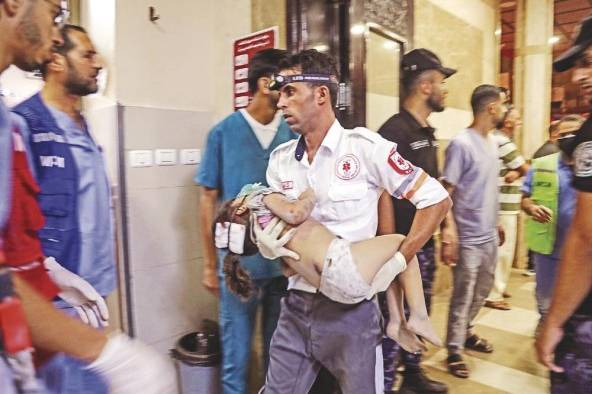 Paramédico atiende a un niño tras la explosión. Paramédico atiende a un niño tras la explosión.