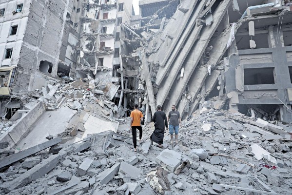 Palestinos inspeccionan los daños en los alrededores del edificio del Banco Nacional que fue destruido tras los ataques aéreos israelíes, en la ciudad de Gaza. Palestinos inspeccionan los daños en los alrededores del edificio del Banco Nacional que fue destruido tras los ataques aéreos israelíes, en la ciudad de Gaza.