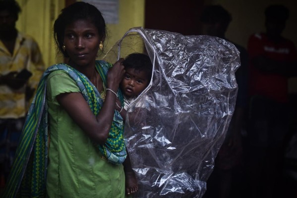 Una mujer y su hijo se cobijan de las fuertes lluvias, este viernes en Chennai (India). Una mujer y su hijo se cobijan de las fuertes lluvias, este viernes en Chennai (India).
