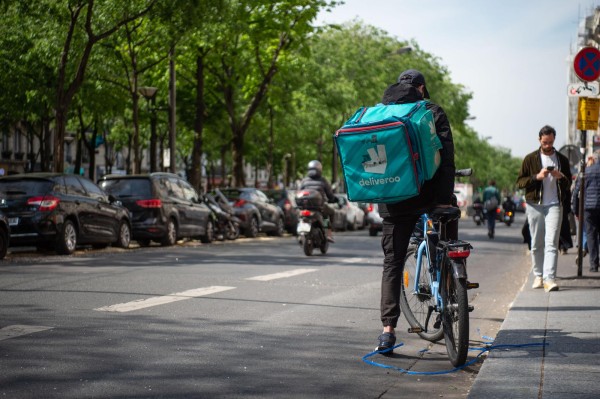Un ciclista con una bolsa de la empresa 'Deliveroo' se detiene en una calle de París, en una imagen de archivo. Un ciclista con una bolsa de la empresa 'Deliveroo' se detiene en una calle de París, en una imagen de archivo.