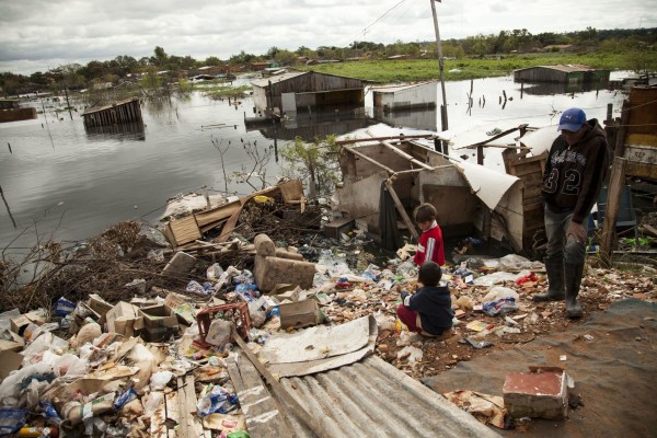 Imagen de archivo que muestra a varias personas cerca a una zona inundada en unos de los campamentos de desplazados de Asunción. Imagen de archivo que muestra a varias personas cerca a una zona inundada en unos de los campamentos de desplazados de Asunción.