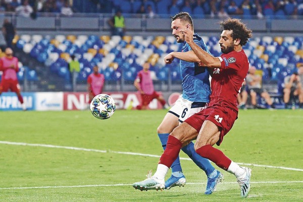 Mario Rui (i) del Napolés le pelea la esférica a Mohamed Salah, del Liverpool. Mario Rui (i) del Napolés le pelea la esférica a Mohamed Salah, del Liverpool.