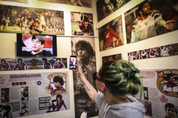 Una mujer toma fotografías en un bar temático de Maradona, el 21 de octubre de 2022, en el barrio de la Boca, en Buenos Aires (Argentina). Una mujer toma fotografías en un bar temático de Maradona, el 21 de octubre de 2022, en el barrio de la Boca, en Buenos Aires (Argentina).