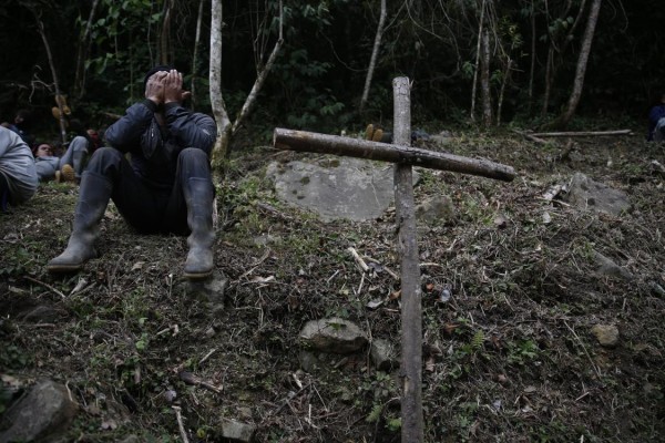 Un minero se cubre el rostro luego de un operativo militar en el corregimiento Pichendé a unos 16 km de Cali (Colombia). Un minero se cubre el rostro luego de un operativo militar en el corregimiento Pichendé a unos 16 km de Cali (Colombia).