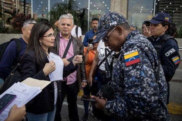 Una mujer explica a miembros de la Policía las razones de la protesta de un grupo de personas hoy, en la entrada del Ministerio de Educación en Caracas, Venezuela. Una mujer explica a miembros de la Policía las razones de la protesta de un grupo de personas hoy, en la entrada del Ministerio de Educación en Caracas, Venezuela.