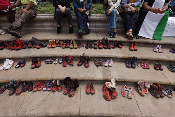 Un grupo de personas junto a zapatos teñidos de rojo, se manifiestan hoy, frente al palacio de La Moneda, en Santiago de Chile. Un grupo de personas junto a zapatos teñidos de rojo, se manifiestan hoy, frente al palacio de La Moneda, en Santiago de Chile.